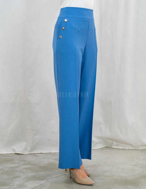 Jasnoniebieskie eleganckie spodnie damskie z szeroką nogawką i rzędowymi guzikami CORALLINE- MODA SANOK Jasnoniebieskie eleganckie spodnie damskie z szeroką nogawką i rzędowymi guzikami CORALLINE- MODA SANOK