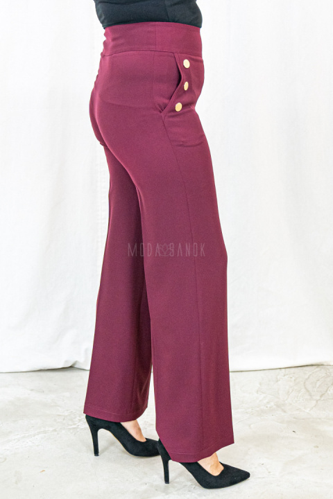 Bordowe eleganckie spodnie damskie z szeroką nogawką i rzędowymi guzikami CORALLINE- MODA SANOK Bordowe eleganckie spodnie damskie z szeroką nogawką i rzędowymi guzikami CORALLINE- MODA SANOK